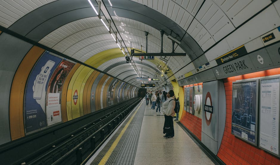 An underground subway platform at Green Park station featuring a curved, tiled ceiling with yellow, white, and black sections. The platform has a smooth, light-colored surface with yellow safety lines
